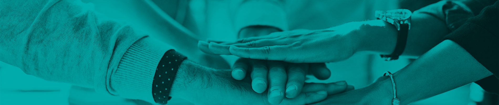 Shot of a group of colleagues joining hands in solidarity outdoors